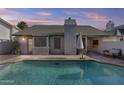 A serene swimming pool in a private backyard with a covered patio and desert landscaping at 7536 W Sequoia Dr, Glendale, AZ 85308