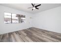 Bright living room with wood-look floors, ceiling fan, and large window for natural light at 7801 N 44Th Dr # 1003, Glendale, AZ 85301