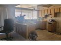 Dated kitchen with laminate cabinets, worn countertops, and a breakfast bar at 7962 W Lincoln St, Peoria, AZ 85345