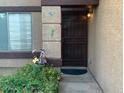 Inviting front entryway with decorative hummingbirds, secure door, and lush flower garden at 8338 W Coolidge St, Phoenix, AZ 85037