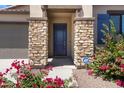 Home's entryway featuring stone accents on the columns and a security system for added protection at 8350 W Carole Ln, Glendale, AZ 85305
