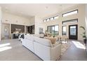 Open concept living room features high ceilings, large windows, neutral furniture, and tiled floors at 8366 E Old Paint Trl # 3, Scottsdale, AZ 85266