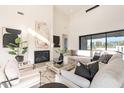 Bright living room with high ceilings, modern fireplace, neutral furniture, and minimalist decor at 8366 E Old Paint Trl # 3, Scottsdale, AZ 85266