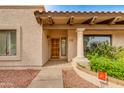 Charming front entrance with decorative column, stucco exterior, and a custom wooden door at 9008 N 83Rd St, Scottsdale, AZ 85258