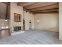 Spacious living room featuring a brick fireplace, vaulted ceilings with wooden beams, and neutral carpet flooring at 9008 N 83Rd St, Scottsdale, AZ 85258
