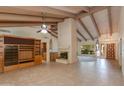 Expansive living area boasting tiled floors, a brick fireplace, and wood-beamed ceilings for rustic charm at 9008 N 83Rd St, Scottsdale, AZ 85258