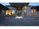 Modern home featuring a textured brick driveway leading to a gray stone and stucco facade at 9750 E Troon North Dr, Scottsdale, AZ 85262