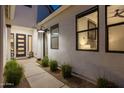 A modern entryway featuring a stylish door, decorative lighting, and sleek landscaping for a welcoming ambiance at 10127 E Tillman Ave, Mesa, AZ 85212