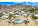 Aerial view of community featuring pool, lush landscaping, covered parking, and mountain views under a clear, blue sky at 10215 N 8Th St # B, Phoenix, AZ 85020