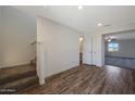A staircase leads to a living room area featuring modern wood-look flooring and a view of the carpeted space at 1074 W West Virginia Ave, Florence, AZ 85132