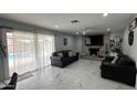 Cozy living room with a stone fireplace, tile flooring, and sliding door access to the pool at 11250 N 33Rd Ave, Phoenix, AZ 85029