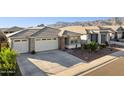 Beautiful house featuring desert landscaping, and a three-car garage against a mountain backdrop at 12176 E Chevelon Trl, Gold Canyon, AZ 85118