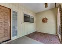 Cozy front porch featuring a wooden door with a brick-paved floor and wall decor at 12811 N 44Th Dr, Glendale, AZ 85304