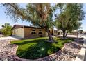 Landscaped front yard featuring artificial grass for easy maintenance in xeriscaped yard at 12811 N 44Th Dr, Glendale, AZ 85304