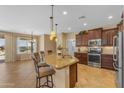 Elegant kitchen featuring granite countertops, wooden cabinets, stainless steel appliances, and barstool seating at 17179 S 174Th S Dr, Goodyear, AZ 85338