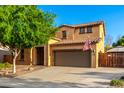 Charming two-story home with a two-car garage, mature tree, and an inviting entrance, creating an appealing curb presence at 17363 W Lisbon Ln, Surprise, AZ 85388