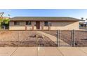Charming single-story home with a neutral-toned exterior, gravel landscaping, and a fenced front yard at 1751 W Carol Ave, Mesa, AZ 85202