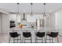 Modern kitchen boasts stainless steel appliances, granite countertops, pendant lighting, and a breakfast bar with seating at 18808 W Solano Dr, Litchfield Park, AZ 85340