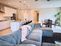 Open-concept living room showcases a large gray sectional, connecting to the modern kitchen with bar seating at 18808 W Solano Dr, Litchfield Park, AZ 85340