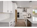 Modern kitchen boasting white countertops, stainless steel appliances, ample storage, and a black faucet at 21348 N Belt Dr, Maricopa, AZ 85138