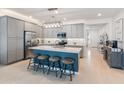 Modern kitchen featuring stainless steel appliances, a large island with seating, and elegant gray cabinetry at 24638 N 144Th Ave, Surprise, AZ 85387