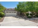 Inviting single-story home featuring a two-car garage, well-kept landscaping, and mature trees for shade at 2957 E Melrose St, Gilbert, AZ 85297