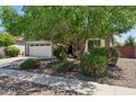 Attractive single-story home with a two-car garage, lush landscaping, and mature trees enhancing its curb appeal at 2957 E Melrose St, Gilbert, AZ 85297