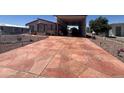 Wide and patterned concrete driveway with covered parking, offering ample space and curb appeal at 316 S 74Th Way, Mesa, AZ 85208