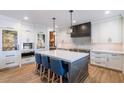 Modern kitchen with white cabinets, a large island with seating, and stainless steel appliances at 3813 W Lapenna Dr, New River, AZ 85087
