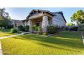 Beautiful home with lush landscaping, stone accents, and a welcoming front porch, perfect for relaxing outdoors at 4565 N Point Ridge Rd, Buckeye, AZ 85396