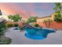 Enjoy a private backyard oasis with a freeform pool, rock waterfall, and lush landscaping at 4565 N Point Ridge Rd, Buckeye, AZ 85396