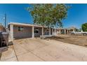 Long driveway to single-story house with mature tree, painted in light gray with white trim at 5022 W Pierson St, Phoenix, AZ 85031