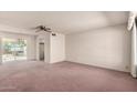 Spacious living room featuring carpet flooring, neutral paint and a large window providing natural light at 6027 E Ellis St, Mesa, AZ 85204