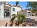 View of the front yard showcasing a palm tree and the home's gray garage door at 6164 E Greenway Ln, Scottsdale, AZ 85254