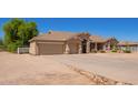 Wide angle of the exterior of a single-story home, including a three-car garage and desert landscaping at 9658 W Golddust Dr, Queen Creek, AZ 85144