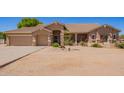 Inviting single-story home with a tan exterior, stone accents, and a desert landscape providing an inviting appeal at 9658 W Golddust Dr, Queen Creek, AZ 85144