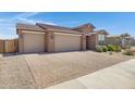 Attractive home exterior showcasing a spacious three-car garage and brick driveway at 1221 E Jahns Dr, Casa Grande, AZ 85122