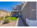 Attractive home facade with a desert landscape, walkway, and white front door at 12801 W Sweetwater Ave, El Mirage, AZ 85335