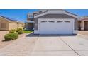 View of house facade featuring the two-car garage and desert landscaping at 12801 W Sweetwater Ave, El Mirage, AZ 85335