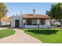 Charming single-story home featuring a red tile roof, lush lawn, and welcoming front porch with a brick walkway at 1309 W Lynwood St, Phoenix, AZ 85007