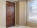 Inviting foyer with decorative window and wood door providing an abundance of natural light at 15562 W Cameron Dr, Surprise, AZ 85379