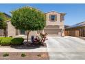 Charming exterior with a well-kept lawn and colorful flowering bushes, complemented by desert landscaping at 15562 W Cameron Dr, Surprise, AZ 85379