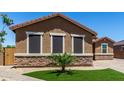 Attractive single-story home showcasing stone accents, multiple windows, and desert-friendly landscaping at 15740 W Washington St, Goodyear, AZ 85338