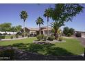 Attractive home featuring a well-maintained lawn, mature trees, and a welcoming entrance at 16386 W Papago St, Goodyear, AZ 85338