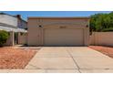 Spacious two-car garage with neutral exterior, complemented by low-maintenance landscaping at 19833 N 47Th Ln, Glendale, AZ 85308