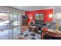 Cozy living room boasts hardwood floors, a gray sofa, and seamless access to the patio at 2033 E Hillery Dr, Phoenix, AZ 85022