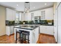 Bright kitchen featuring white cabinetry, modern appliances, granite countertops, and an island with bar seating at 20704 N 90Th Pl # 1015, Scottsdale, AZ 85255