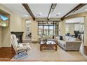 Cozy living room with hardwood floors, a fireplace, exposed beams, and a large window for natural light at 20704 N 90Th Pl # 1015, Scottsdale, AZ 85255