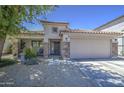 Inviting single-story home featuring a two-car garage and a well-maintained front yard with desert landscaping at 22333 E Calle De Flores St, Queen Creek, AZ 85142