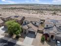 Scenic aerial view of a home with desert surroundings, complemented by solar panels at 22812 N 123Rd Dr, Sun City West, AZ 85375
